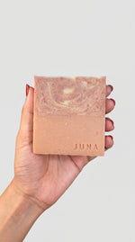 Hand holding a Juna Tangerine Bloom citrus and red clay soap bar photo